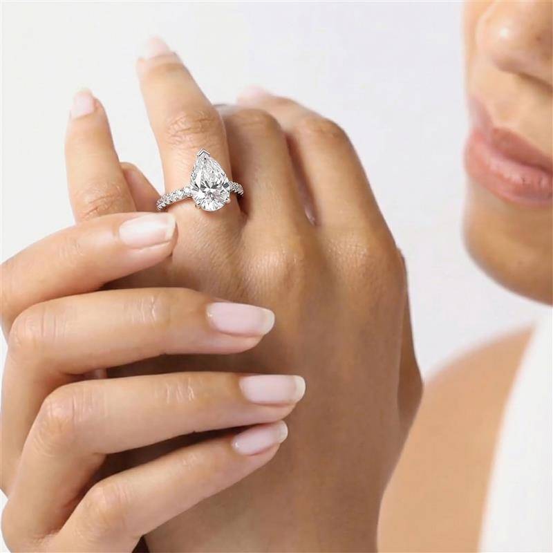 Birnenförmiger Diamantring mit hohem, verstecktem Halo und Schulterfassung