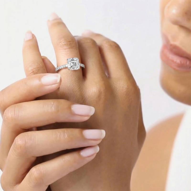 Asscher-Diamantring mit hohem, verstecktem Halo und Schulterfassung